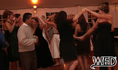 wedding reception guests dancing on the dance floor and Wedding Entertainment Director® logo