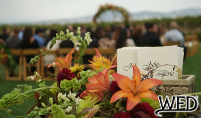 wedding ceremony programs with guests seated in the background and Wedding Entertainment Director® logo