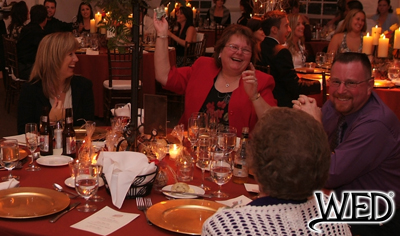 wedding reception guests laughing during the dollar pass and Wedding Entertainment Director® logo